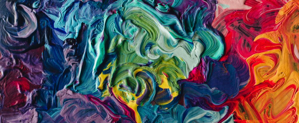 An up-close photo of a canvas with overlapping swirls of bright colors