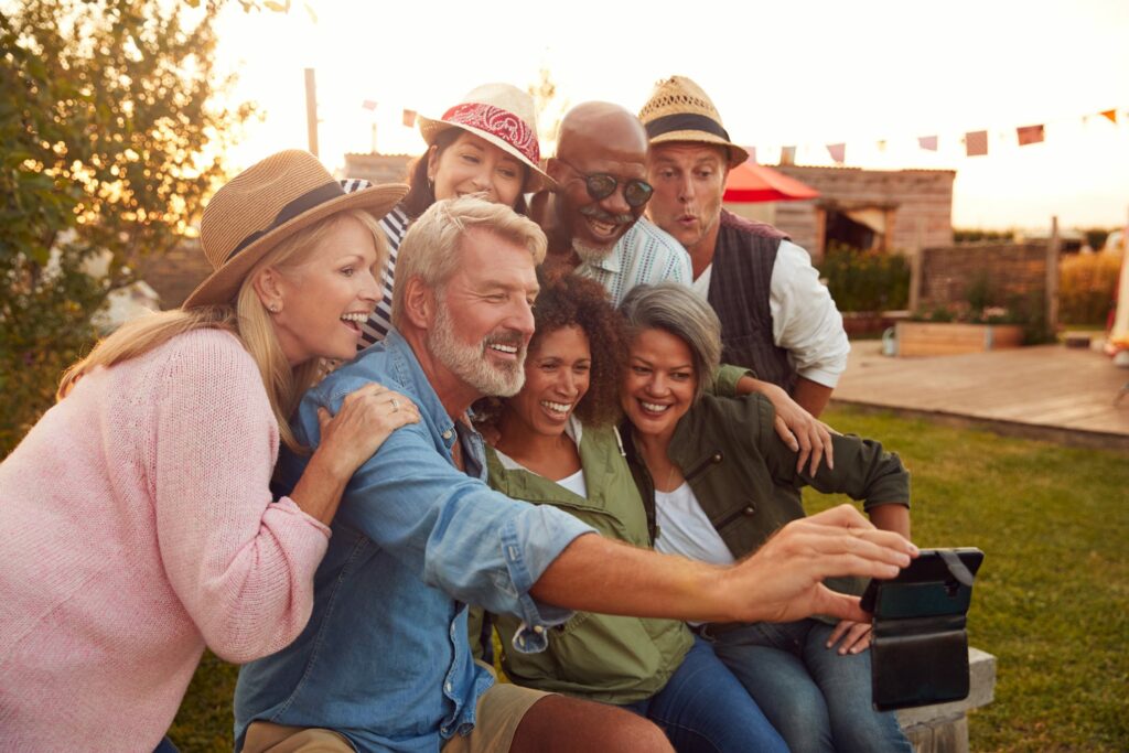 group-of-adults-sitting-on-bench-taking-selfie