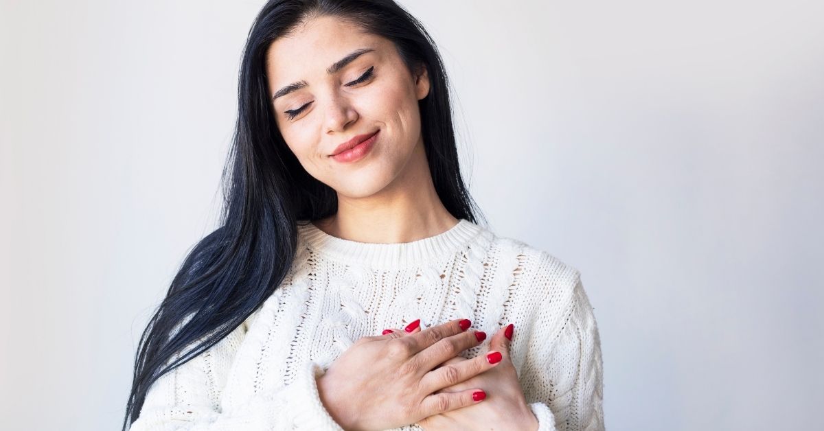 A woman with her hands over her heart.