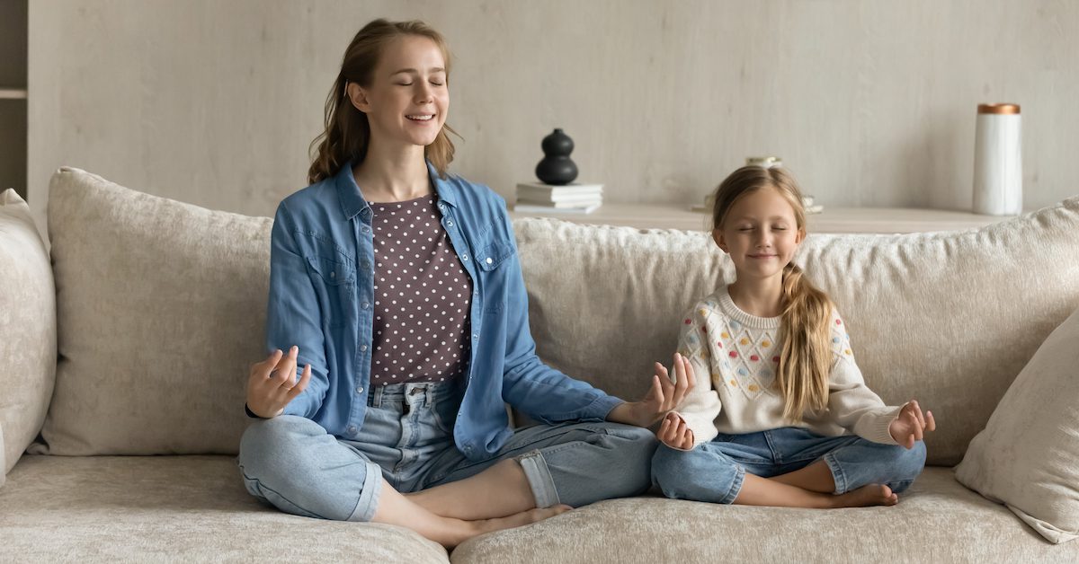 A mother and daughter practicing mindful breathing together.