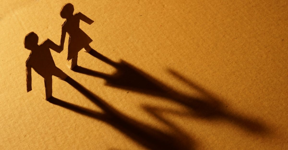 A relationship concept featuring a cardboard cutout of a couple and their shadows.