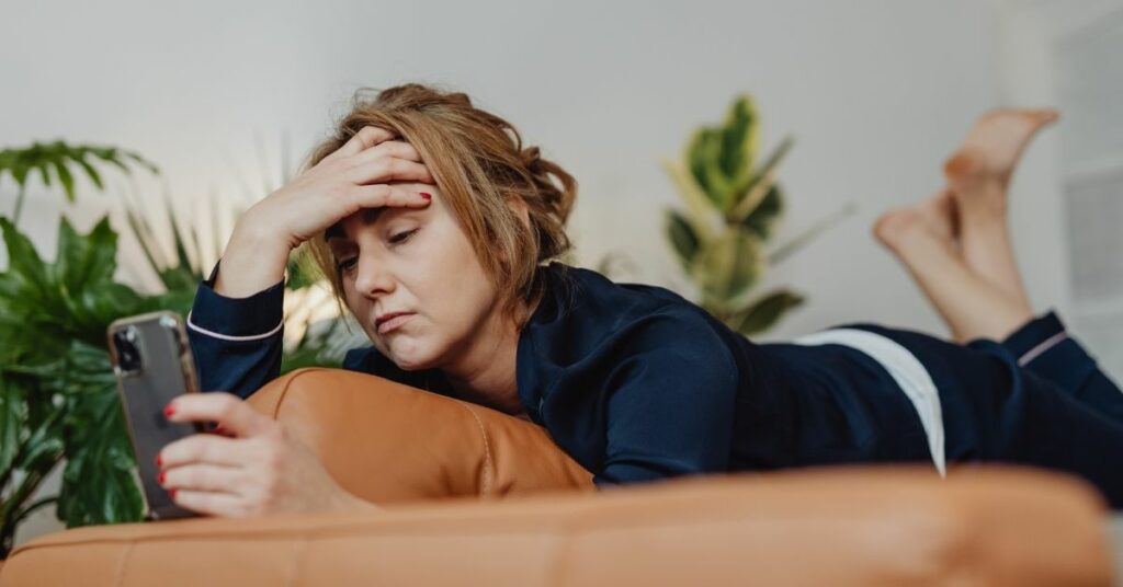 A stressed woman looking at her smartphone.