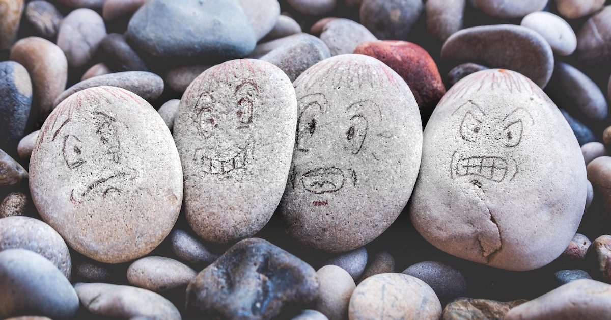 Faces drawn on stones showing different emotions.