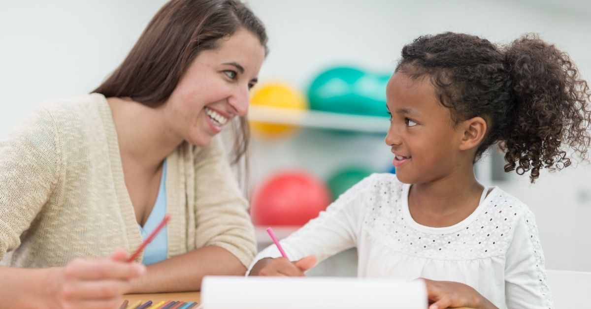 A therapist with a child during a writing exercise.