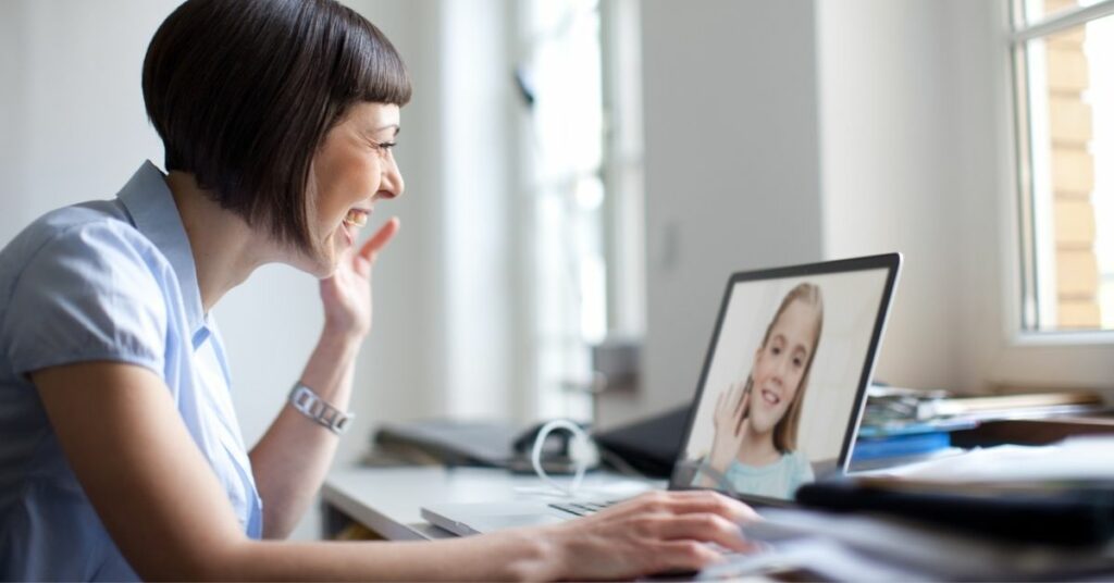 A child therapist holding a telehealth session with a young girl.