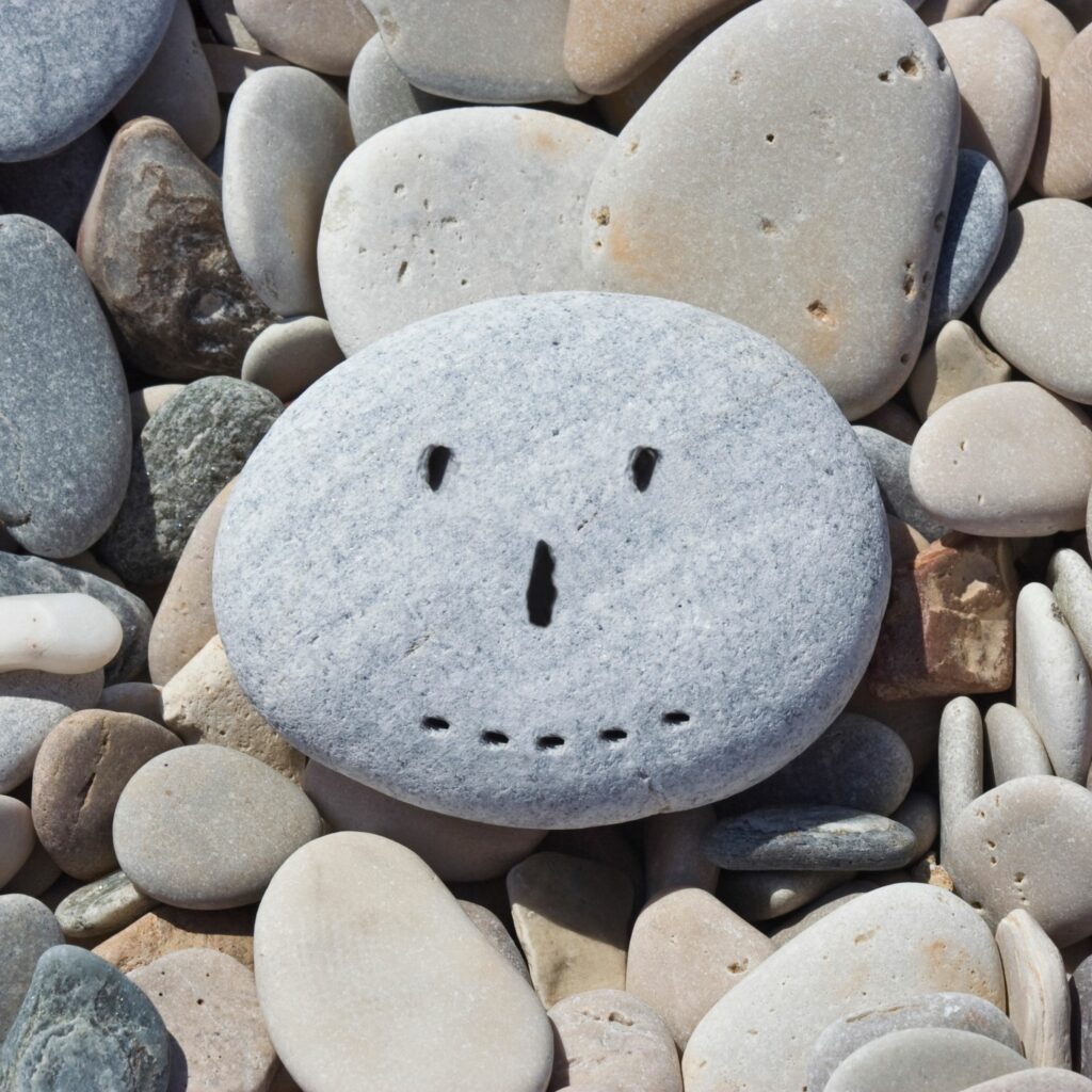 A happy face drawn on a rock.