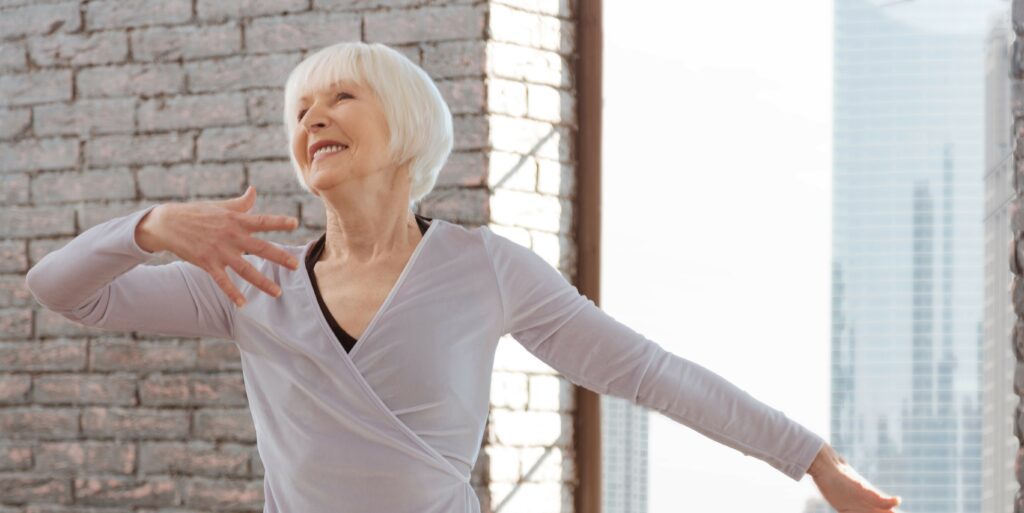 Image of a woman in a dance class smiling in the middle of a spin