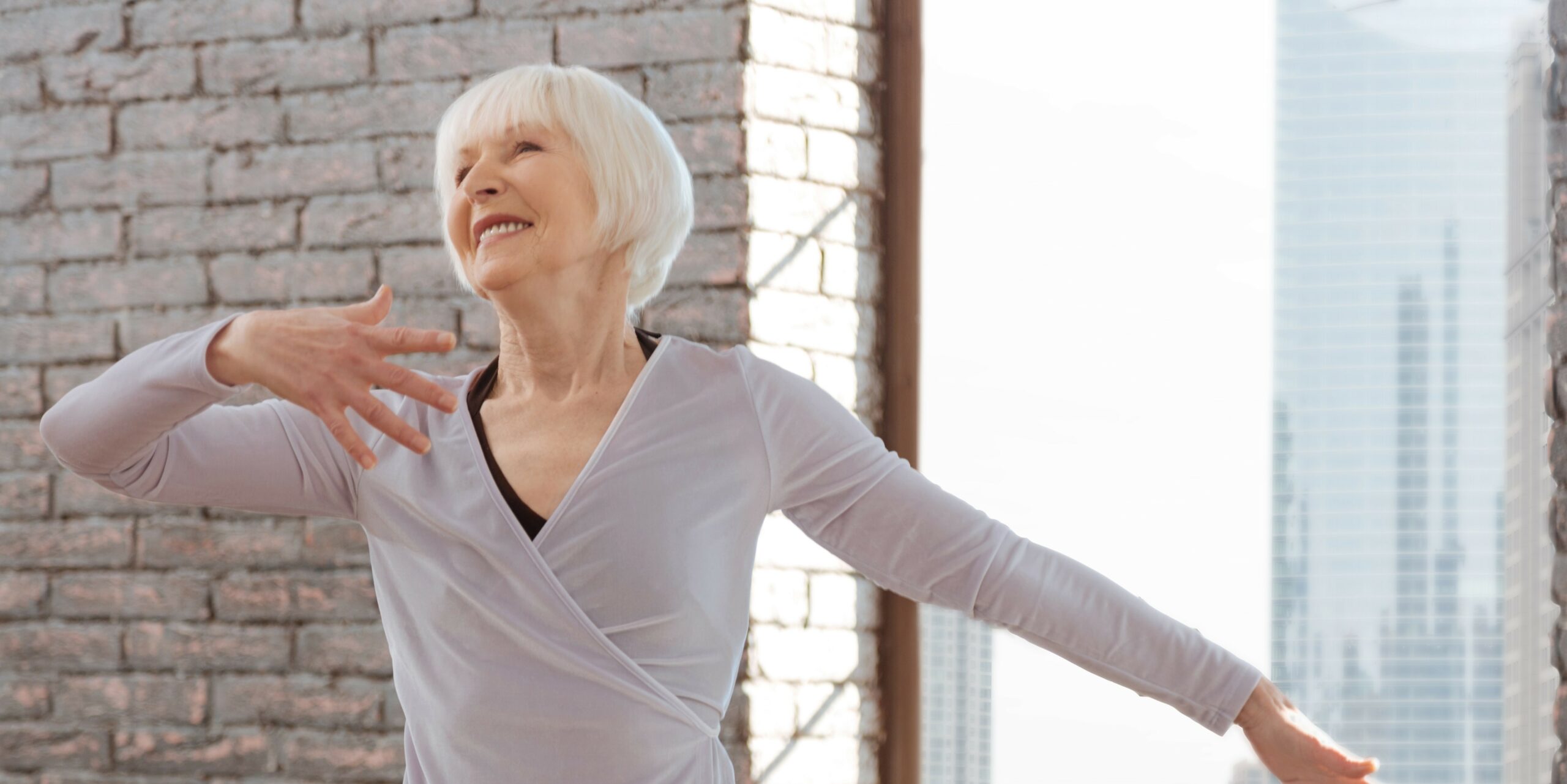Image of a woman in a dance class smiling in the middle of a spin