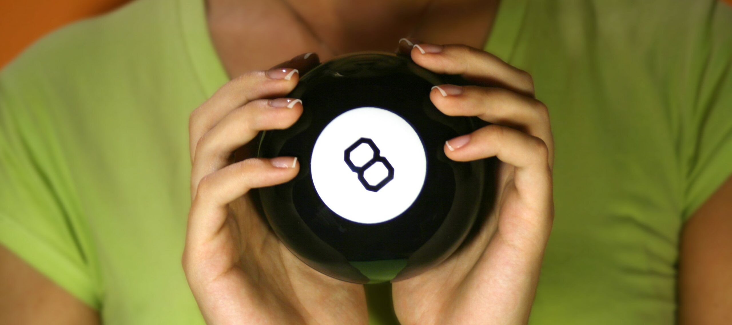 A pair of hands holds up a magic 8 ball