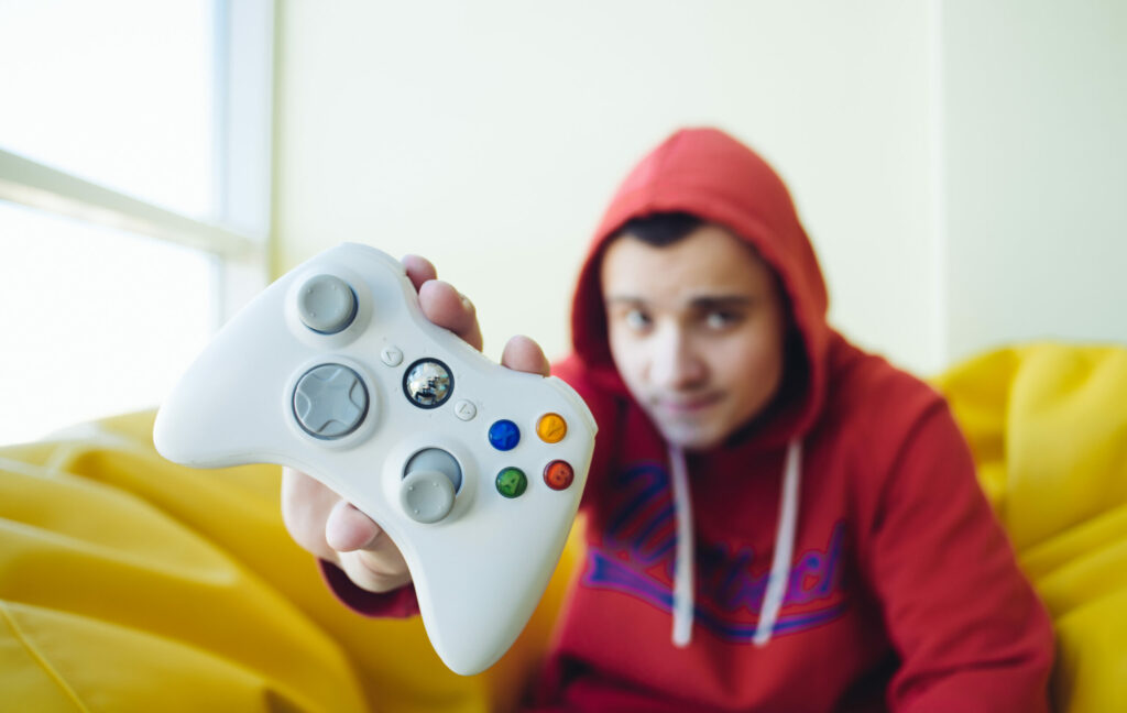 Young white male gamer holds up joystick