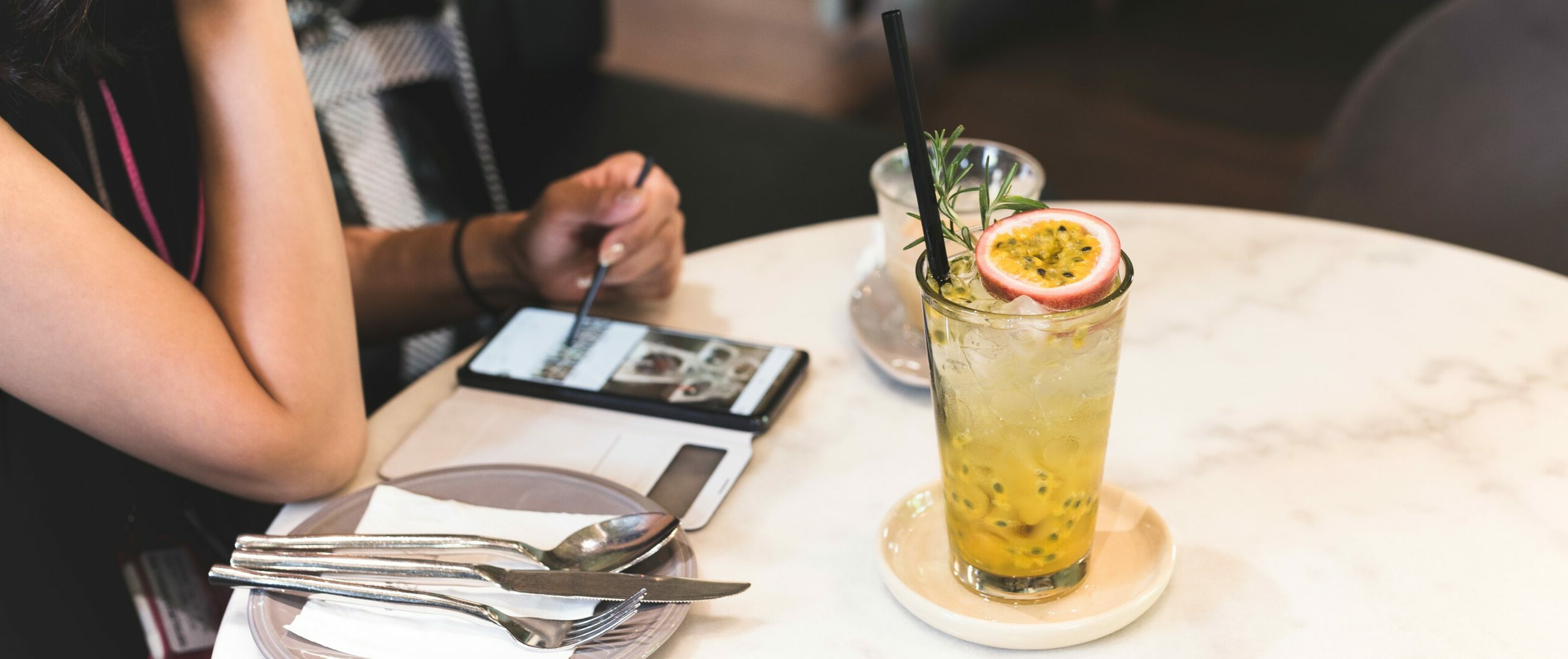 A drink with garnishes sits on a tabletop