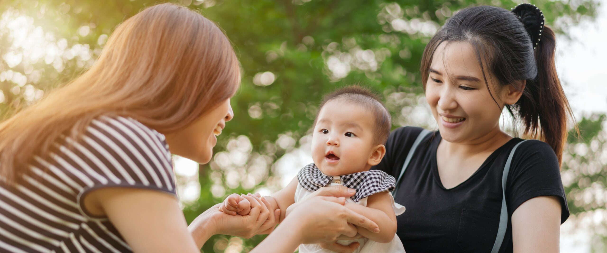 Two women play with a baby