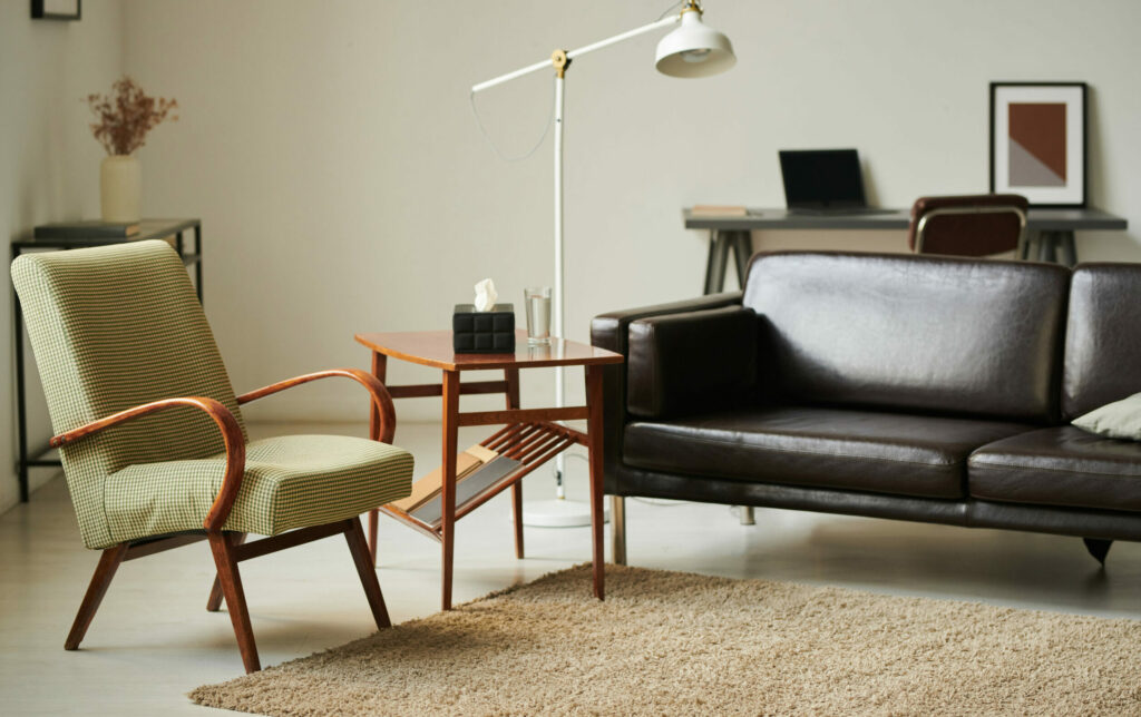 Therapist office with light green chair and dark leather couch