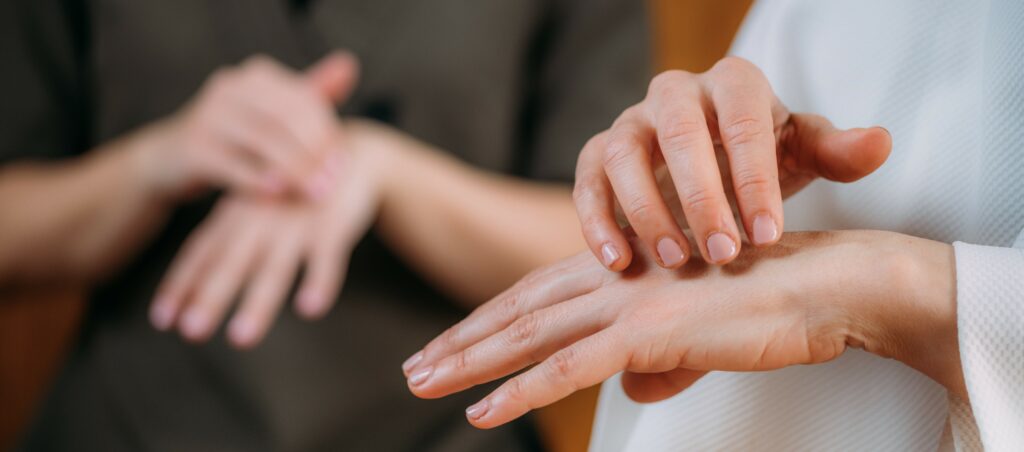Two sets of hands perform a tapping technique, lightly hitting the right-hand fingers on the side of the left hand